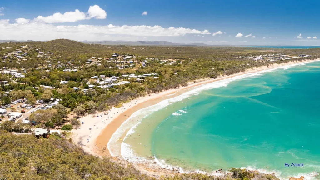 Agnes Water Beach in Queensland, with golden sand, turquoise waves, and a relaxed coastal town backdrop
