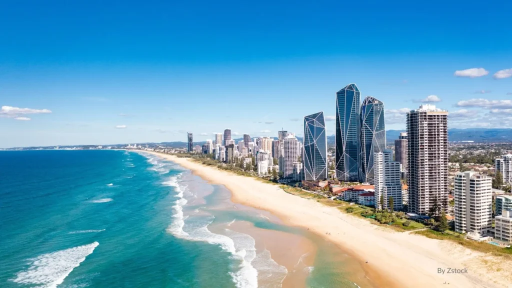 Aerial view of Broadbeach on the Gold Coast, showing golden sandy shoreline, surf waves, and modern high-rise towers
