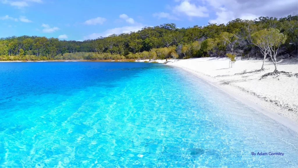 Lake McKenzie on Fraser Island (K’gari), Queensland, with crystal-clear turquoise water, pure white silica sand, and surrounding forest