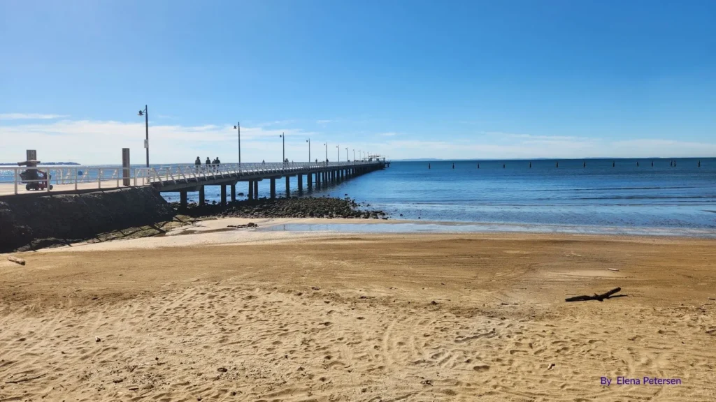 Sandgate Beach foreshore with long pier extending over tidal waters, Brisbane, Queensland