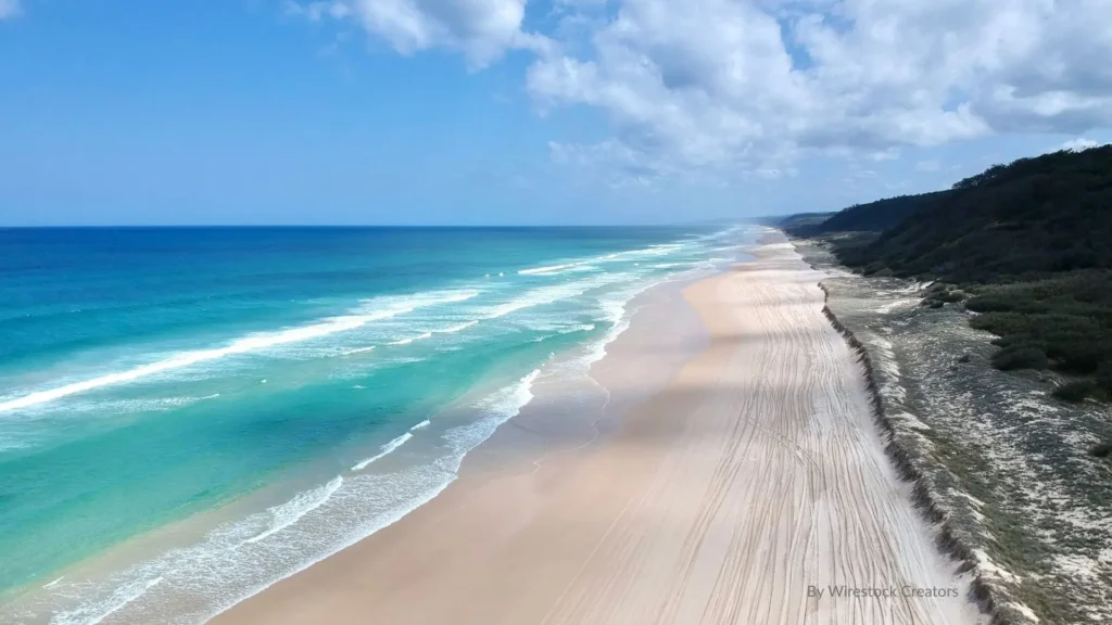 Aerial view of Bribie Island coastline with turquoise ocean waves and long sandy beach, Queensland, Australia