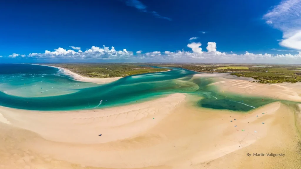 Aerial view of Elliott Heads, Bundaberg Queensland, showing turquoise waters, white sand, tidal flows, and river meeting the reef