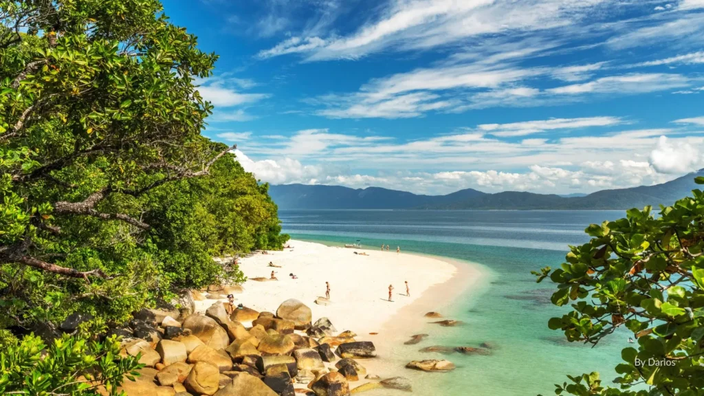 Aerial view of Fitzroy Island with white sandy beach, turquoise reef waters, and lush rainforest, Cairns, Queensland.
