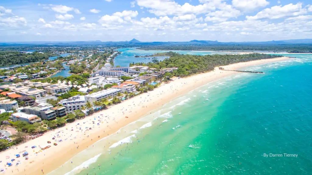 Aerial view of Noosa Heads Main Beach with golden sand, turquoise water, and Hastings Street beachfront resorts, Sunshine Coast, Queensland