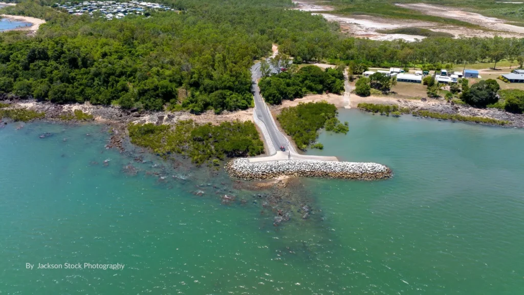 Aerial view of St Helens Beach foreshore with tidal flats, mangroves, and boat ramp access surrounded by coastal bushland, north of Mackay, Queensland.