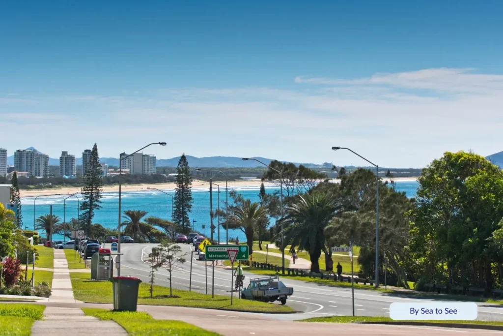 Panoramic view of Alexandra Headland, Sunshine Coast, showing palm-lined streets, coastal skyline, and sparkling turquoise ocean under clear blue skies.
