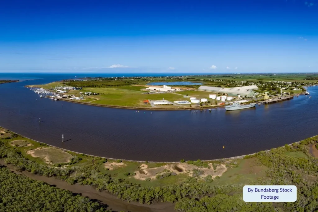 Aerial view of Burnett Heads, Bundaberg Region, Queensland, showing the Burnett River meeting the Coral Sea with marina facilities and coastal greenery