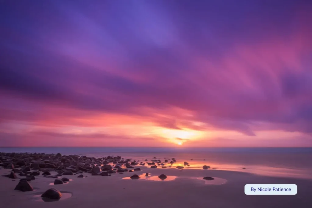 Sunrise over the rock formations at Elliott Heads, Bundaberg, Queensland, with purple and orange hues reflecting across the shoreline