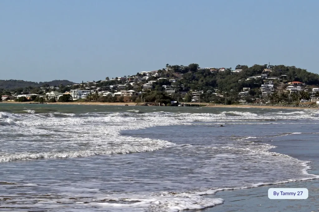 View of Farnborough Beach, Capricorn Coast, Queensland, with gentle surf and hillside homes overlooking the ocean near Yeppoon.