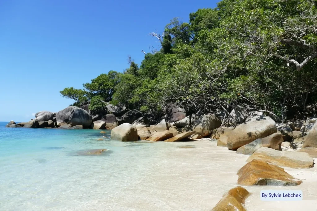 Crystal-clear shallows and granite boulders surrounded by tropical rainforest at Fitzroy Island, Great Barrier Reef, Queensland, Australia.”