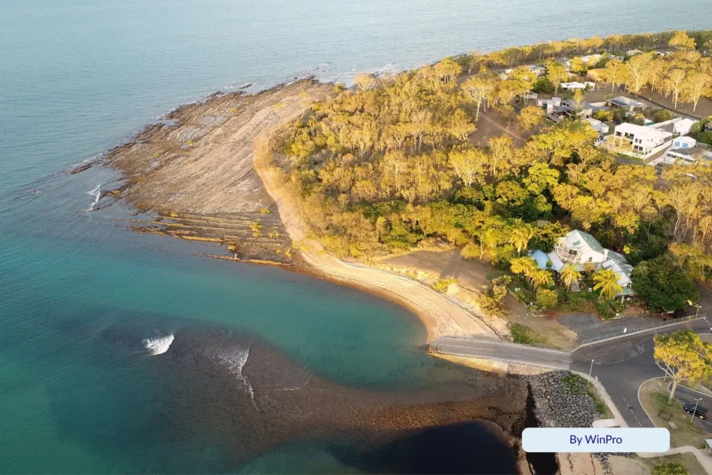 Aerial view of Gatakers Bay Beach at Point Vernon, Hervey Bay Queensland, showing the rocky foreshore, calm turquoise waters, and surrounding coastal bushland.