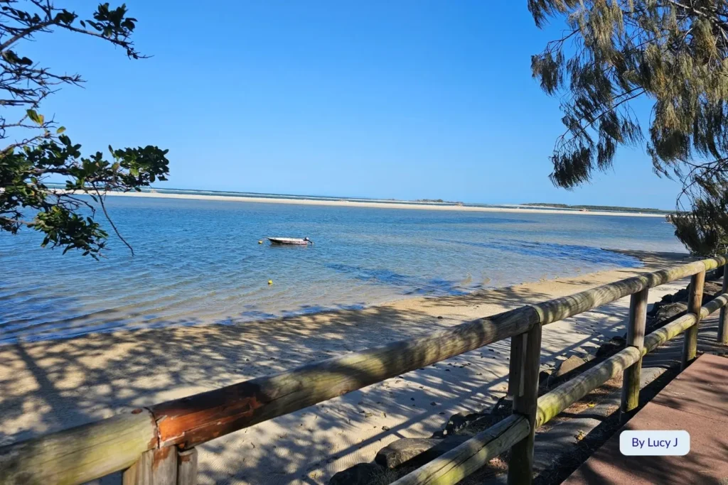 Quiet sandy foreshore and anchored small boat at Golden Beach, Caloundra, with views across Pumicestone Passage, Sunshine Coast, Queensland.