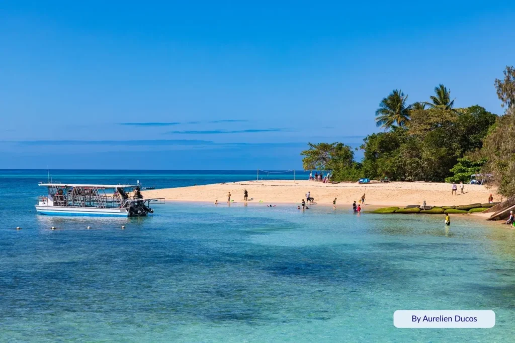 Tour boat anchored off Green Island with visitors swimming and relaxing on the coral sand beach, Great Barrier Reef, Queensland, Australia.