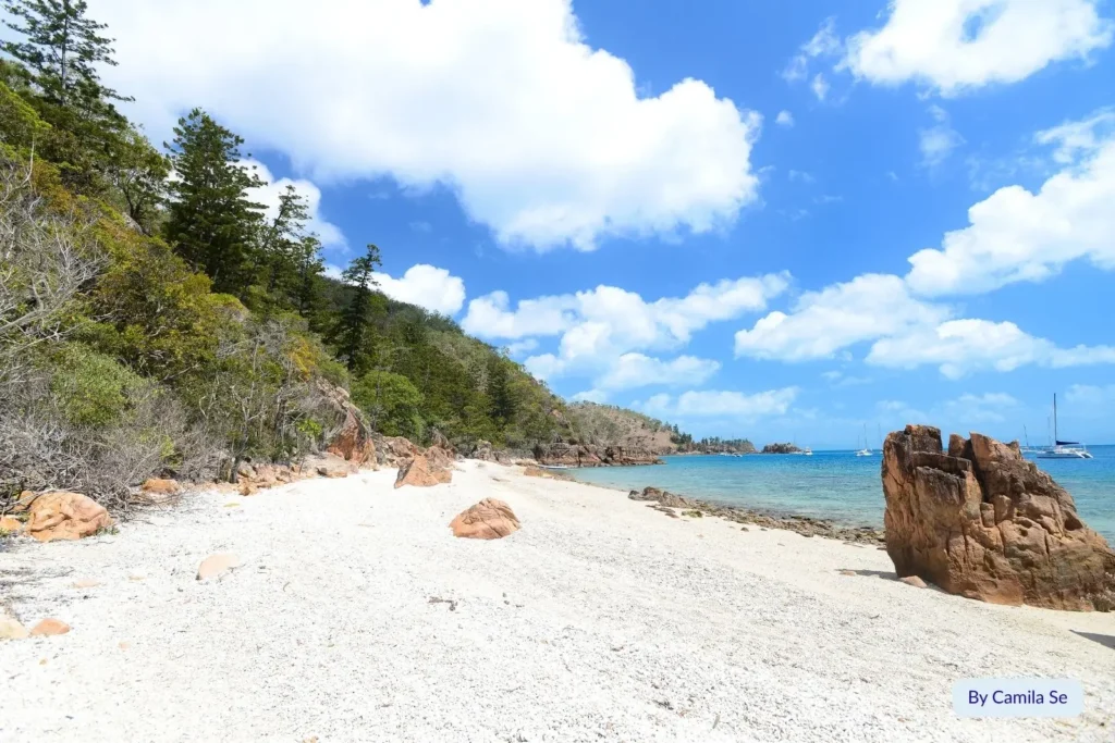 Secluded coral beach with rocky shoreline and turquoise water on Hayman Island, Whitsundays, Queensland, Australia.