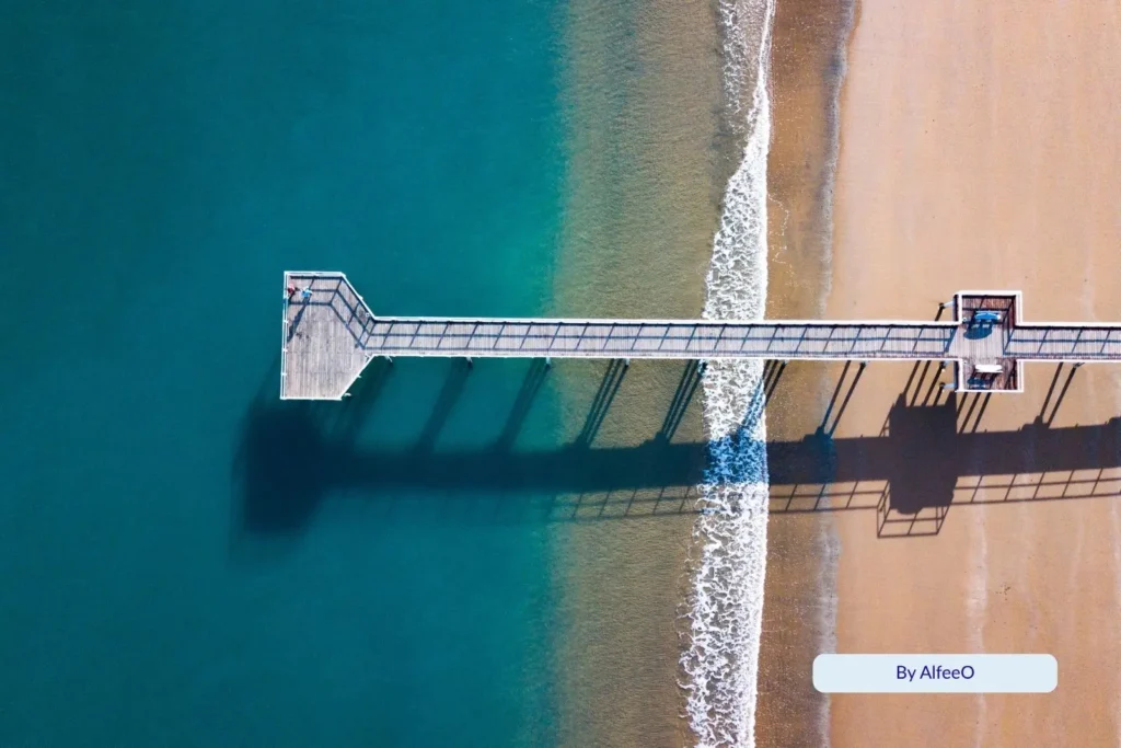 Aerial view of the iconic Urangan Pier stretching over the clear blue waters of Hervey Bay, Queensland.