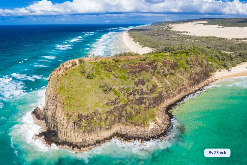 Close-up of the rocky headland at Indian Head, Fraser Island (K’gari), surrounded by vivid blue ocean and untouched coastal dunes.