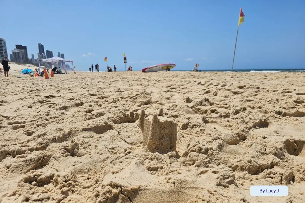 Close-up of soft golden sand and surf lifesaving flags at Kurrawa Beach, Broadbeach, on a sunny day on the Gold Coast, Queensland