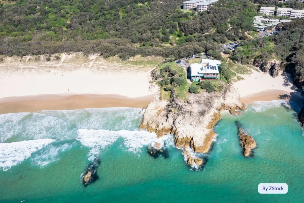 Aerial view of Main Beach, North Stradbroke Island, showing rocky headland and surf near Point Lookout