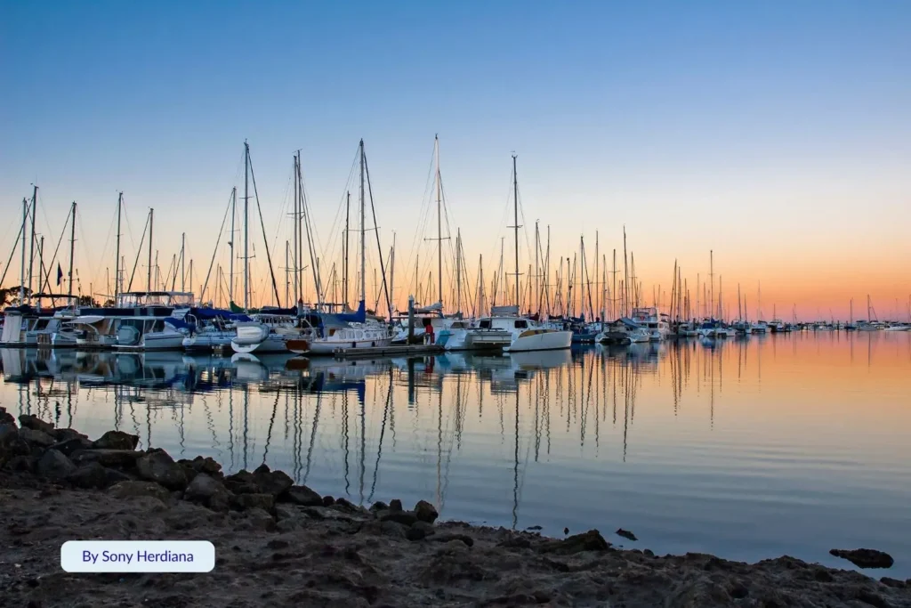 Boats and yachts moored at Manly Boat Harbour in Brisbane, Queensland, reflecting on calm water at sunrise near Manly Beach on Moreton Bay