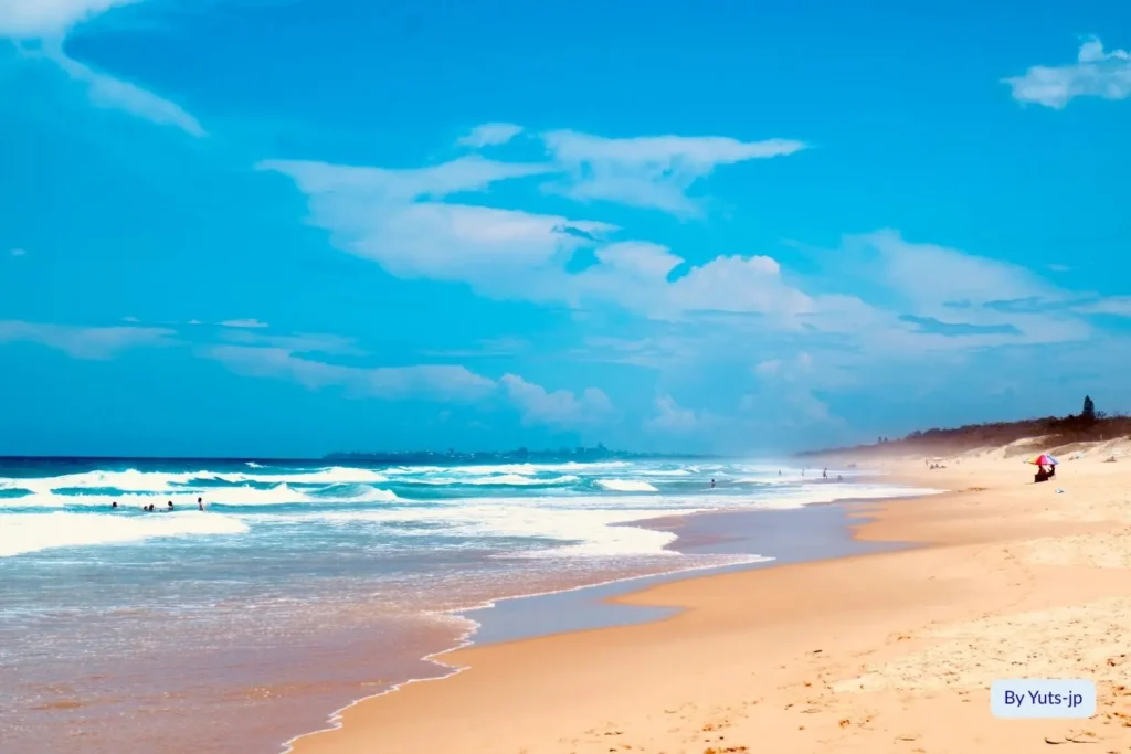 Golden sand and rolling surf at Maroochydore Beach under a bright blue Queensland sky