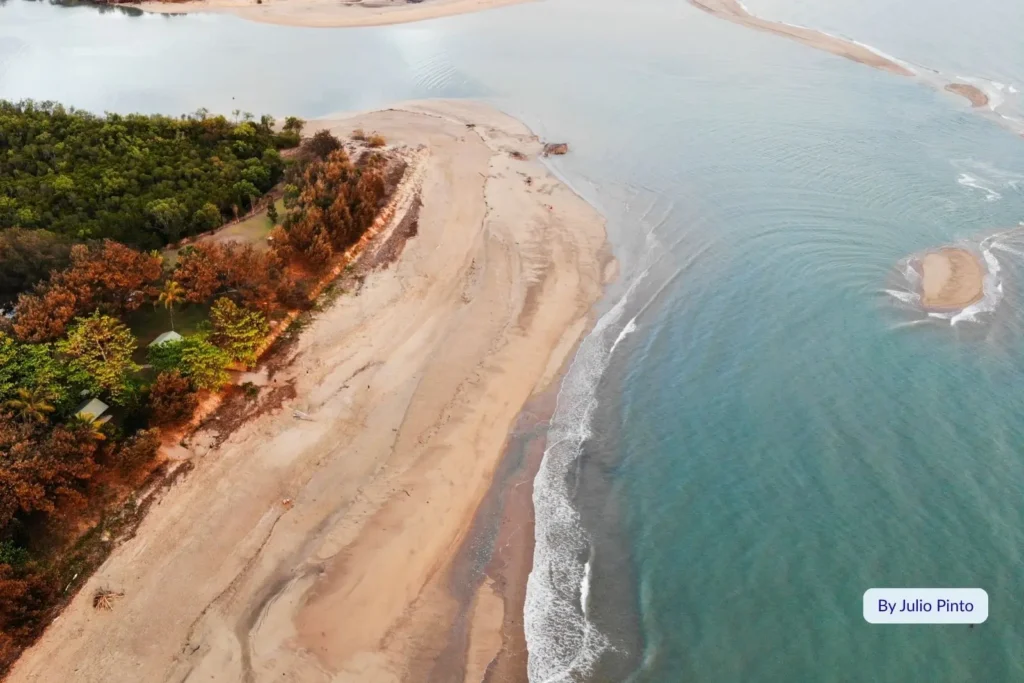 Aerial view of Saunders Beach showing sandy headland, coastal vegetation, and calm blue waters in North Queensland.