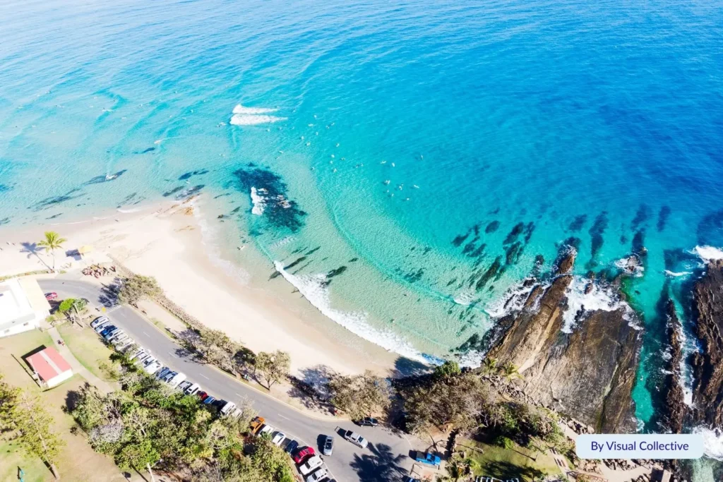 Aerial view of Snapper Rocks, Gold Coast, Queensland, showing turquoise water, rocky headland, and surfers enjoying the famous point break.