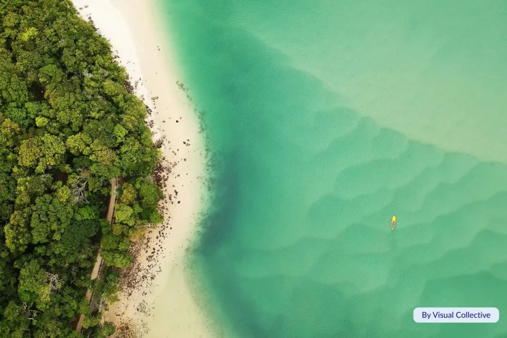 Aerial view of turquoise shallows and lush greenery near Caloundra Beach, Sunshine Coast Queensland coastline.