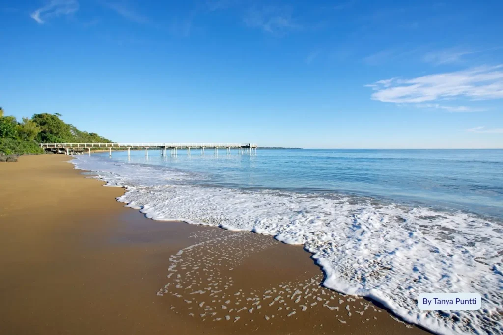 Gentle waves lapping the shore near the historic Urangan Pier on a sunny day, Hervey Bay, Queensland, Australia