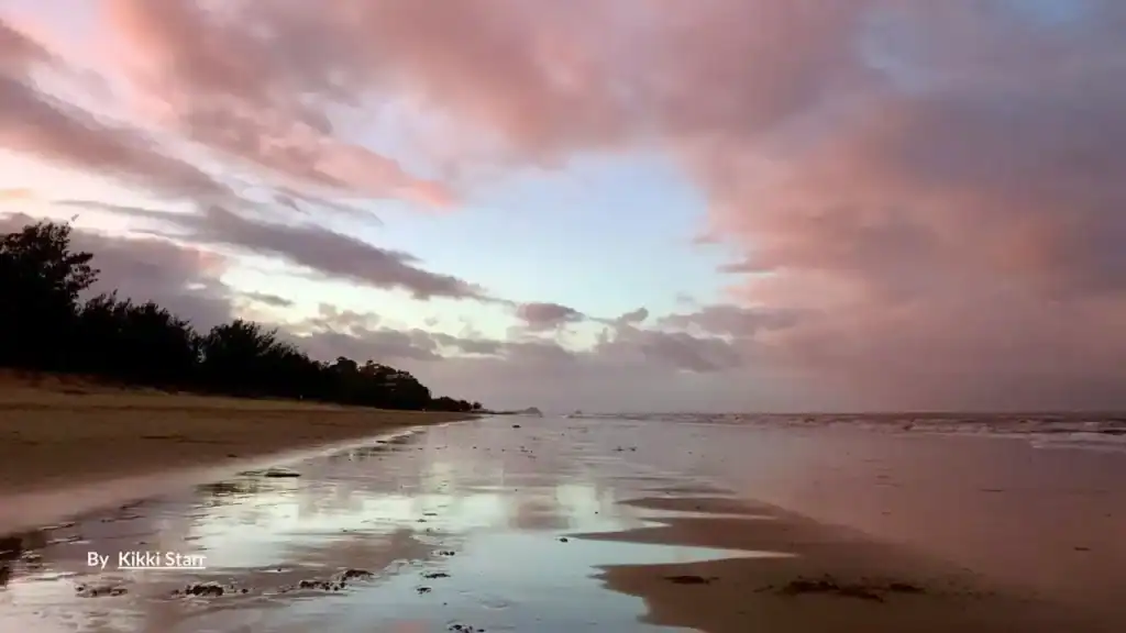 Sunset reflections on wet sand at Yorkeys Knob Beach Cairns