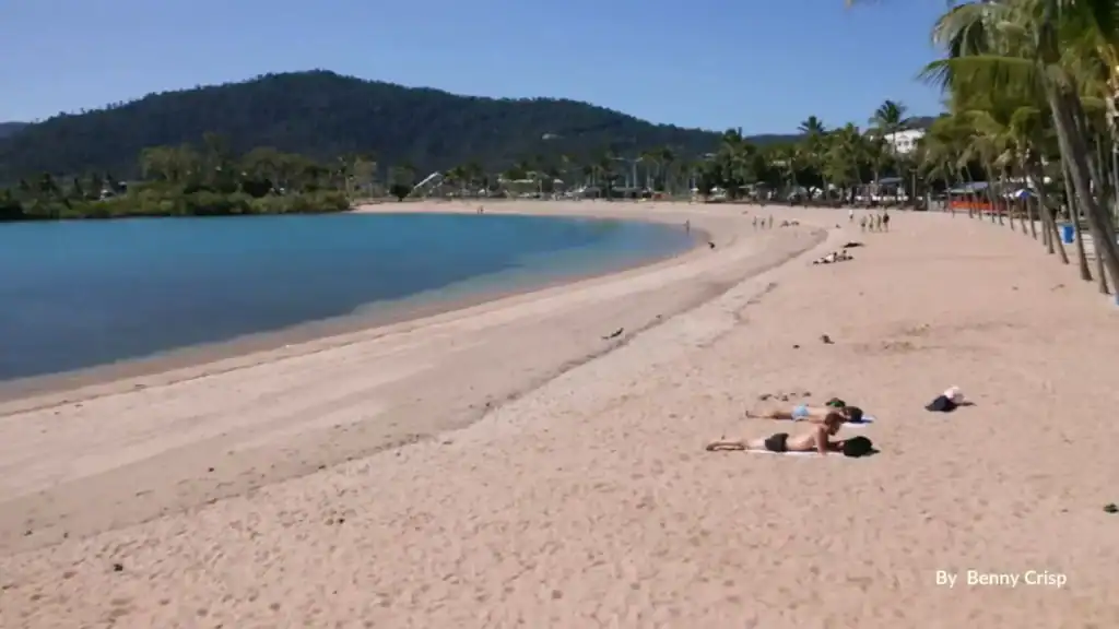 Airlie Beach Lagoon and sandy foreshore with palm trees and visitors, Whitsundays Queensland