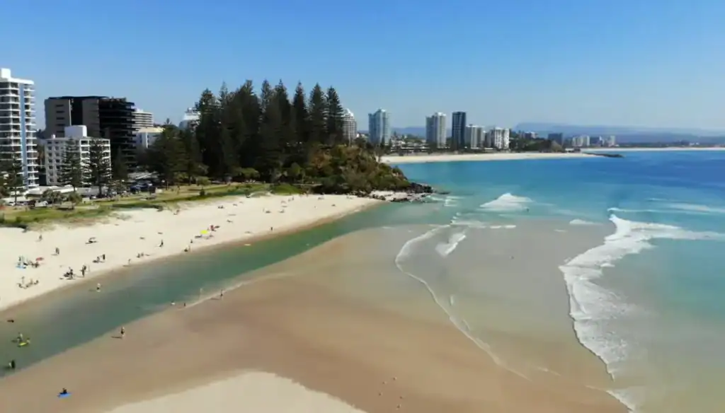 Rainbow Bay Gold Coast beach with golden sand, turquoise water and city skyline