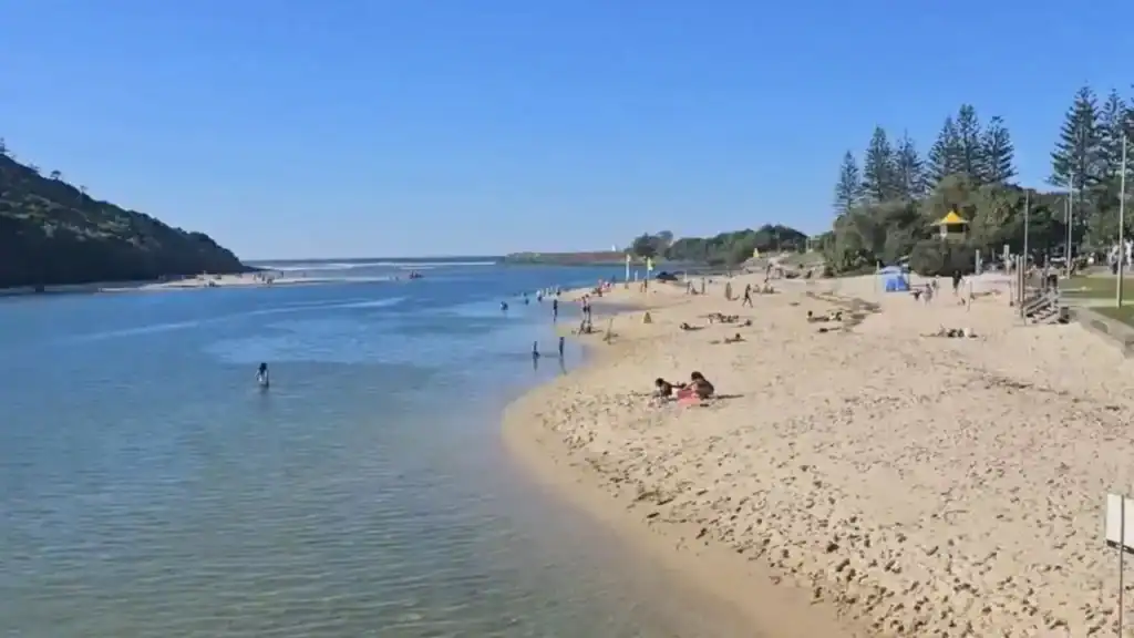 Tallebudgera Creek Beach, Gold Coast with calm creek waters, sandy beach, swimmers and families enjoying the popular sheltered swimming spot