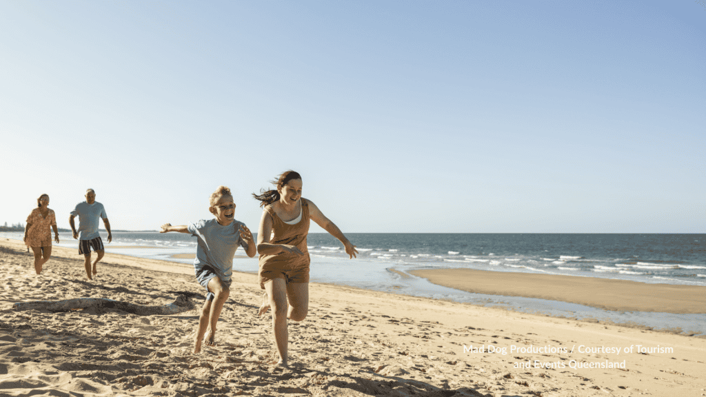 Family running on Woodgate Beach Bundaberg, Queensland