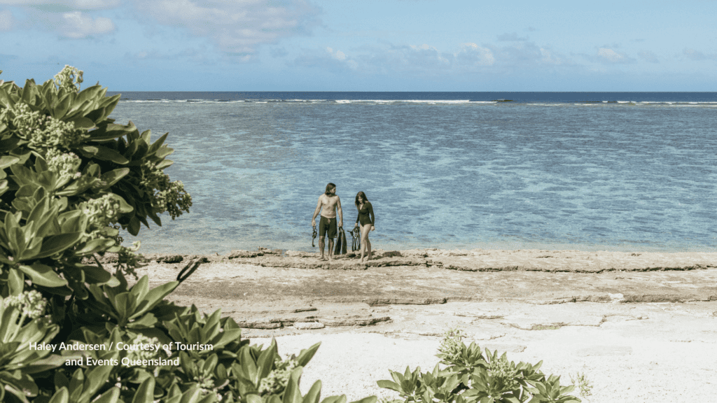 Couple walking the reef flat at Lady Elliot Island with fins