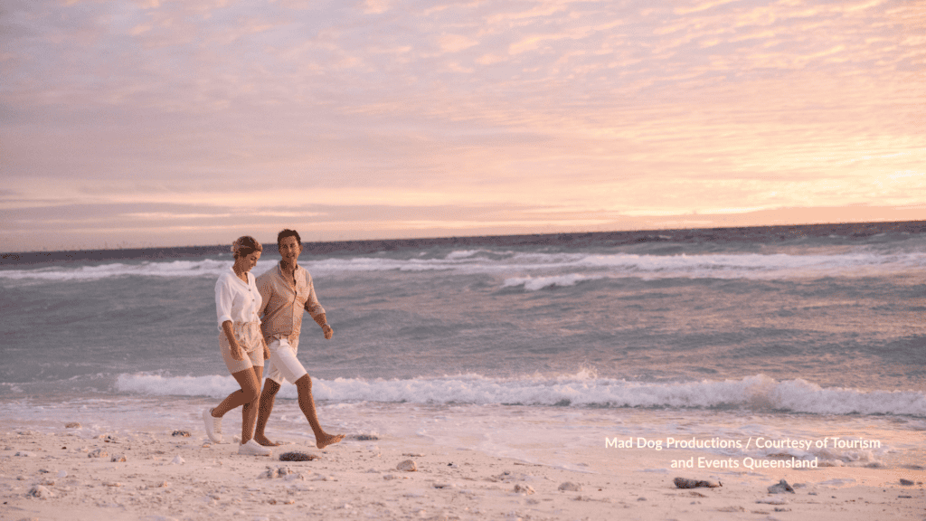 Couple walking the beach at sunrise on Lady Elliot Island