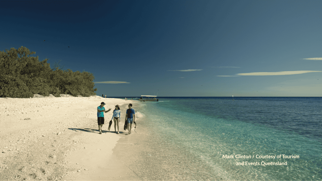 Guests walking the beach at Lady Elliot Island with fins in Queensland