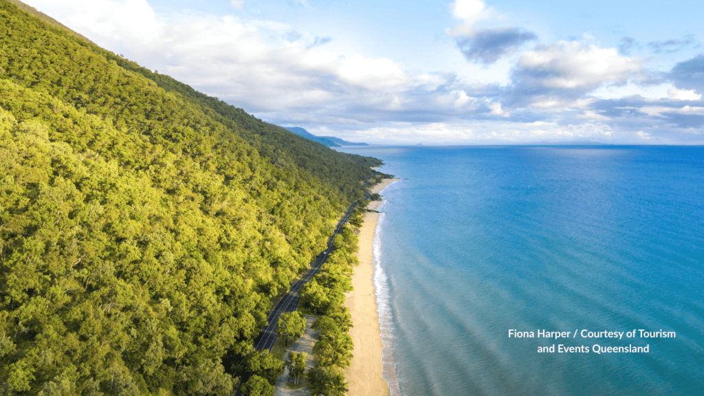 Aerial view of Ellis Beach Cairns Queensland with the Captain Cook Highway running between the rainforest hillside and the long sandy shoreline