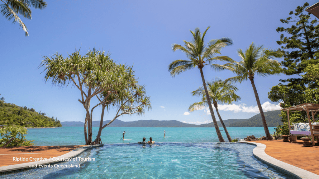 Infinity pool at Elysian Retreat on Long Island Whitsundays Queensland with paddleboarders on the bay