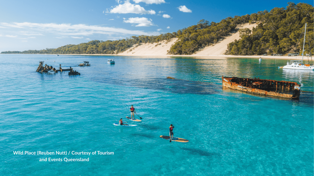 Paddleboarders at the Tangalooma Wrecks on Moreton Island Queensland in clear turquoise water