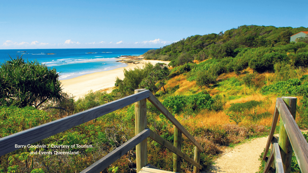 Wooden stairs down to Deadmans Beach Point Lookout with the sandy bay and headland in Queensland