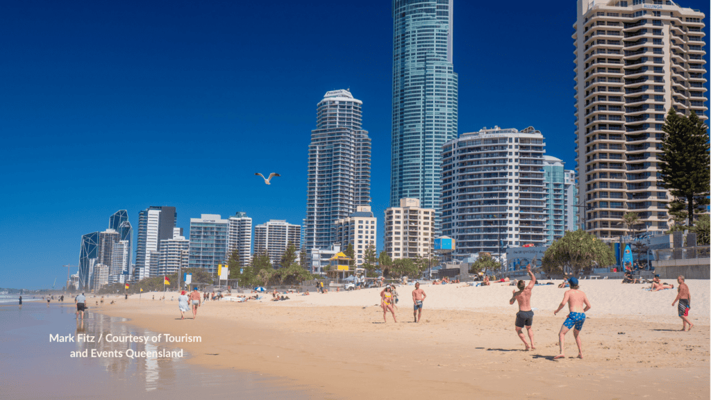 People on the sand at Surfers Paradise Beach Queensland with the Gold Coast skyline behind