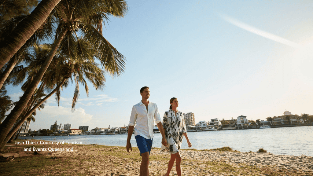 Couple walking the Nerang River sand at Budds Beach Gold Coast Queensland
