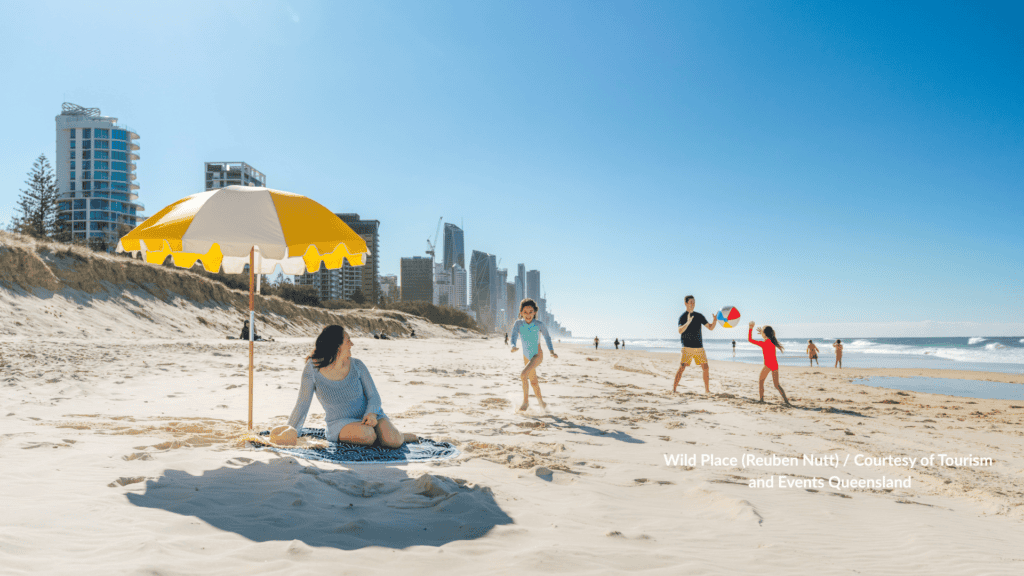 Family on the sand at Kurrawa Beach Broadbeach Queensland with the Gold Coast skyline behind