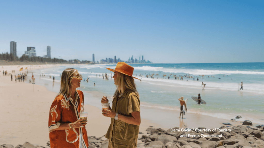 Two friends on the rocks at Burleigh Heads Beach Gold Coast Queensland with the skyline in the distance