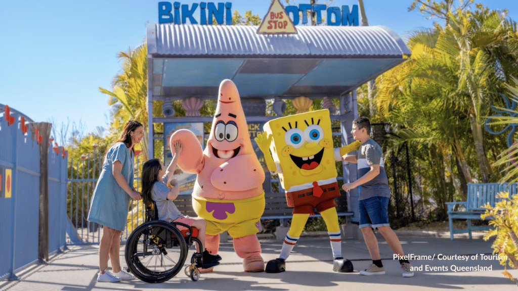 Family meeting SpongeBob SquarePants and Patrick Star at the Bikini Bottom Bus Stop in Nickelodeon Land at Sea World Gold Coast Queensland with a child in a wheelchair joining the photo.