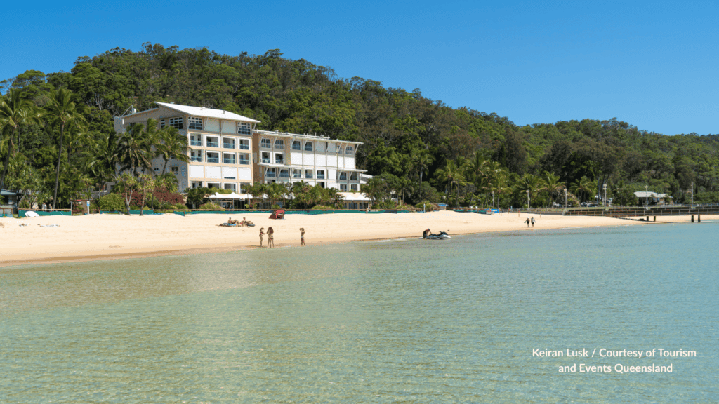 Calm bay water and sandy beach in front of Tangalooma Island Resort on Moreton Island, Queensland with the jetty visible to the right