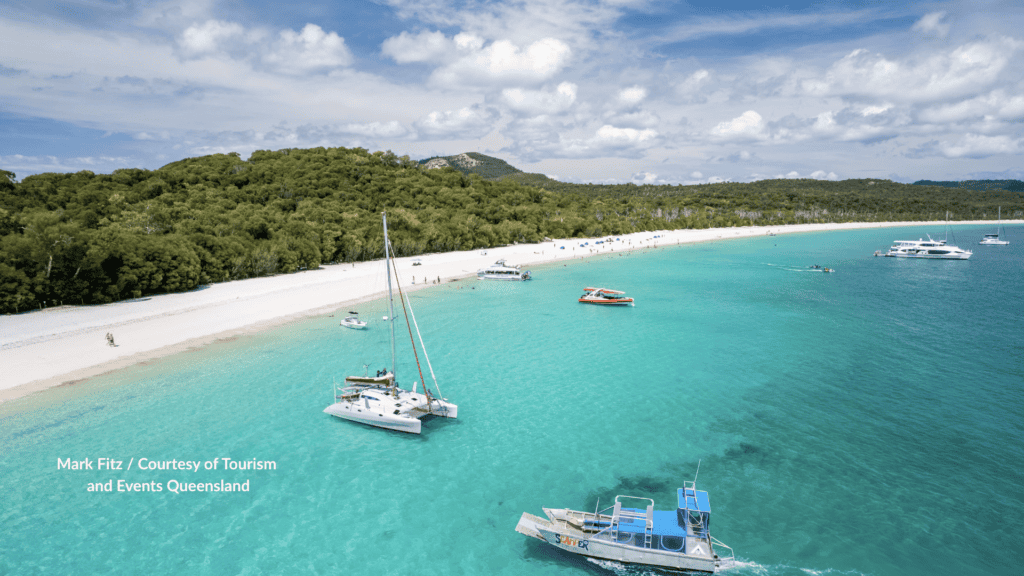 Tour boats and catamarans off the white silica sand of Whitehaven Beach on Whitsunday Island in the Whitsundays Queensland