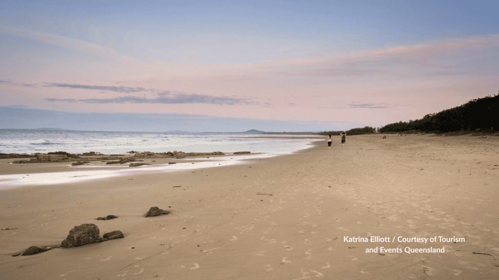 Walkers on Tannum Sands Beach Gladstone at dusk in Queensland