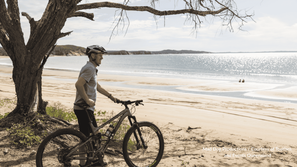 Cyclist with a mountain bike on the beach at Curtis Island Gladstone in Queensland