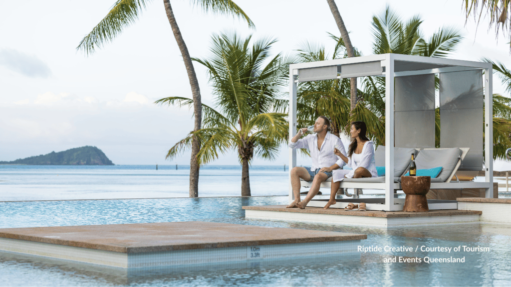 Couple on a poolside cabana at Hayman Island Resort looking over the Whitsundays